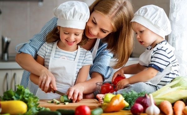 Woman Preparing a Healthy Meal with Two Children