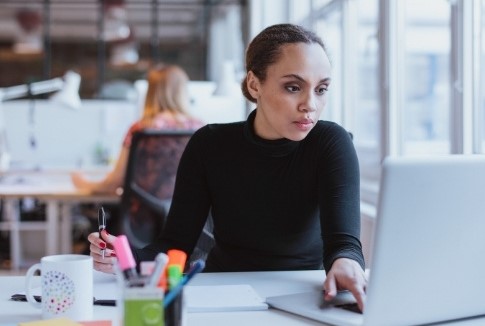 Organizing your tasks well improves productivity at work. Woman Organizing Tasks at Work to Improve Productivity.