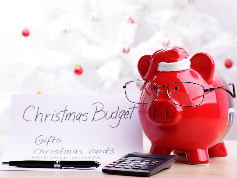 Plan Christmas budget: Note paper, pen, calculator, and a piggy bank with glasses. Plan Christmas budget: Note paper, pen, calculator, and a piggy bank with glasses.