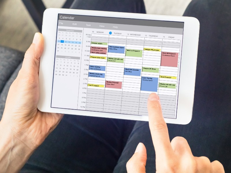 Person using calendar application on a digital tablet.