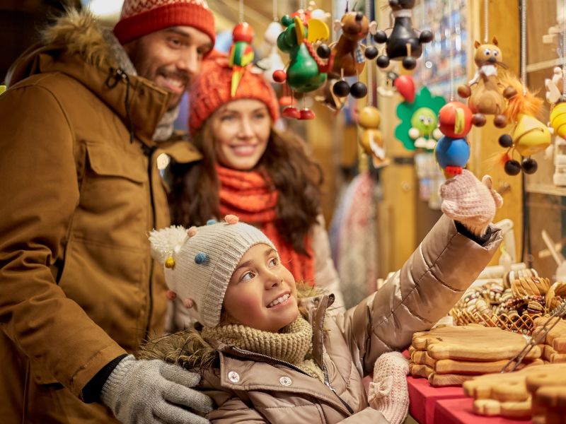 Two adults and a child at a Christmas market. Two adults and a child at a Christmas market.