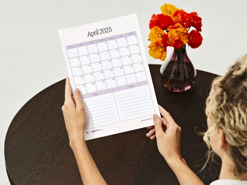 Woman using a free printable 2025 calendar Woman using a free printable 2025 calendar