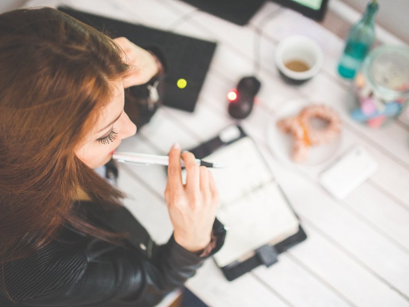 Woman using a planner to organize activities.