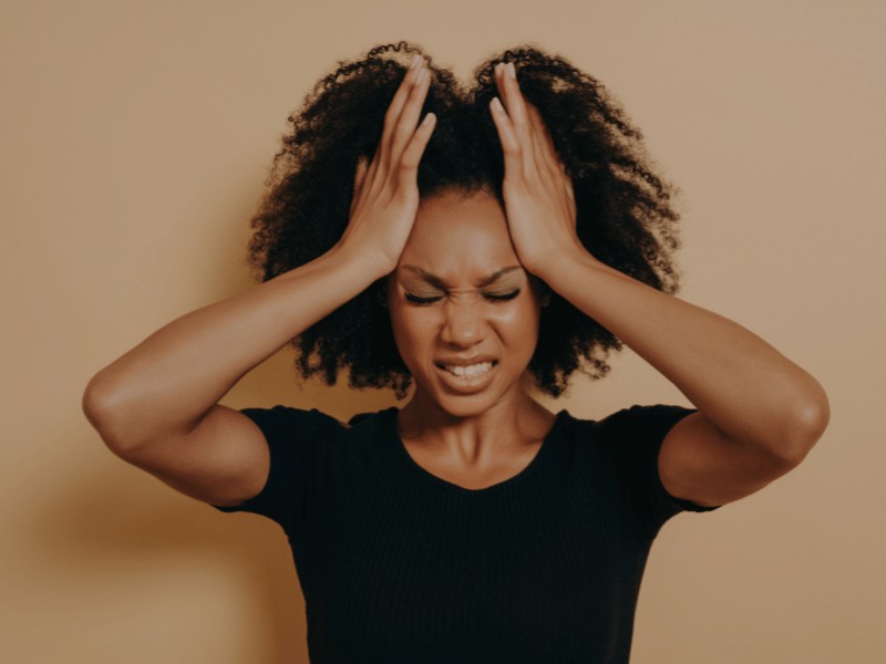 A stressed woman holding her head. A stressed woman holding her head.