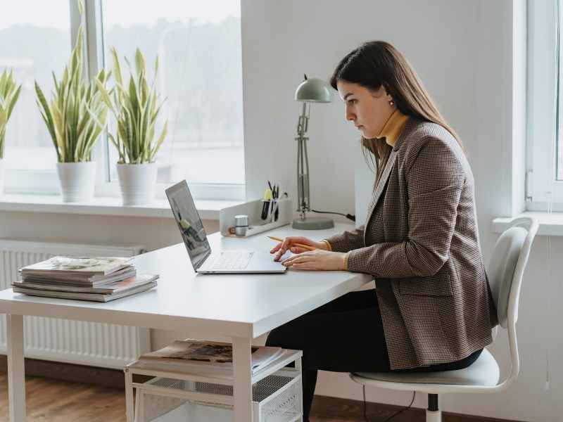 Woman working at a tidy home office desk, representing tips to organize your life.